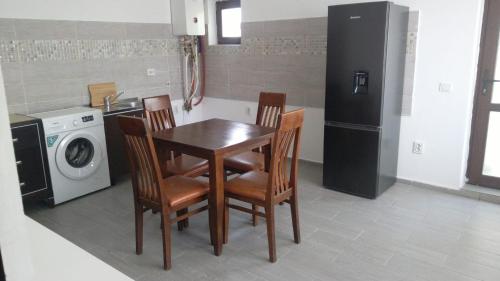a kitchen with a table and chairs and a washing machine at Vila Flight in Aroneanu