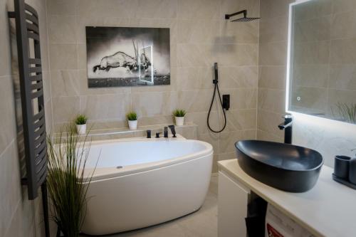 a bathroom with a large white tub and a sink at Stylish apartment in the heart of Tallinn, free parking in Tallinn