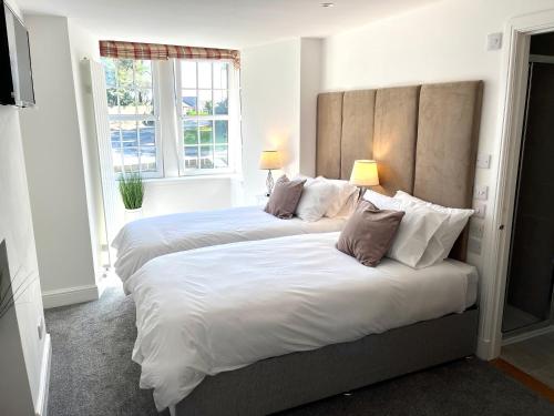 a bedroom with two beds with pillows and a window at Altonhill House - room only in Nairn