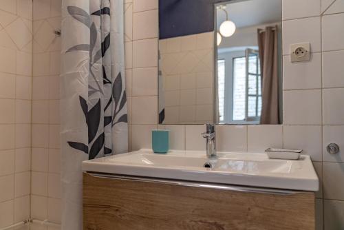 une salle de bain avec un lavabo et un miroir dans l'établissement Coeur écusson - entre les Arènes et la Maison Carrée, à Nîmes