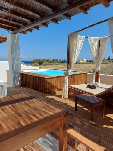 a wooden deck with a pool in the background at Sea breeze houses in Monolithos