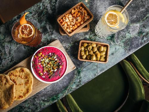 a table topped with bowls of food and a drink at Kimpton - St Honoré Paris by IHG in Paris
