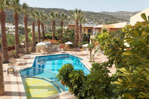 una piscina en un complejo con palmeras en Latania Apartments, en Stalida