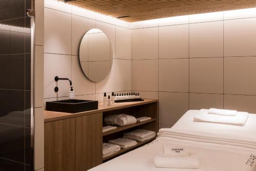 a bathroom with a bed and a sink and a mirror at Kimpton - St Honoré Paris by IHG in Paris