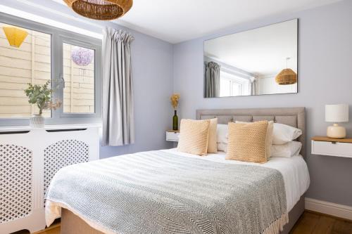 a bedroom with a white bed and a mirror at Tintern Apartment - Clapham in London