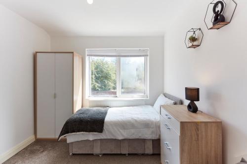 um quarto com uma cama e uma janela em Spacious home close to city centre location em Leeds