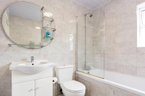 La salle de bains est pourvue de toilettes, d'un lavabo et d'un miroir. dans l'établissement Spacious home close to city centre location, à Leeds