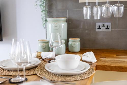 a table with plates and glasses on a table at Tintern Apartment - Clapham in London