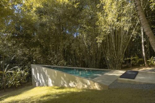 una piscina en medio de un jardín en KA BRU Forest Villa, en Itacaré