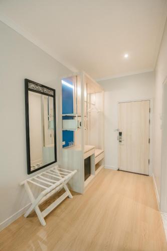a large white room with a mirror and a table at The Park Hotel in Phitsanulok