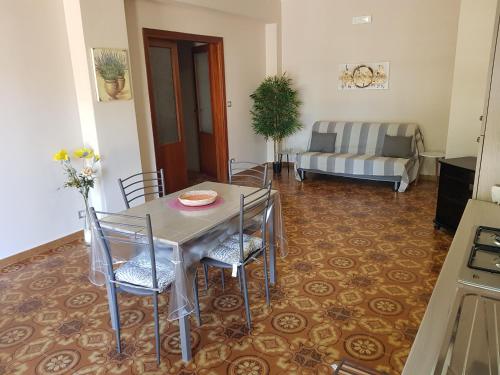 ein Esszimmer mit einem Tisch, Stühlen und einem Sofa in der Unterkunft La Magnolia in San Giorgio a Liri