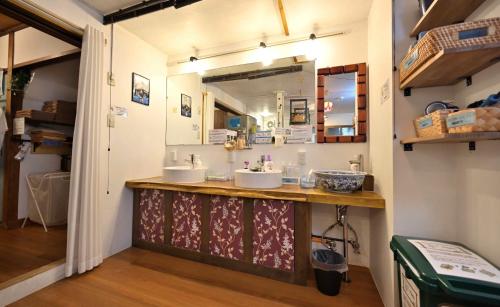 a bathroom with two sinks and a mirror at Hostel Caranashi in Osaka