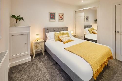 a bedroom with a large white bed with a yellow blanket at Host & Stay - Rochester Apartment in Rochester