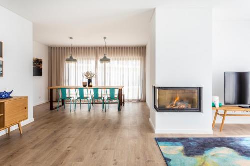 a living room with a fireplace and a table at You and the sea in Ericeira
