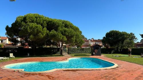 - une piscine dans une cour avec un arbre dans l'établissement Forest Terrace Praia de Mira, à Praia de Mira