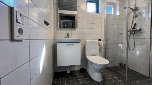 biała łazienka z toaletą i prysznicem w obiekcie Kåvanstugan Funäsdalen w mieście Funäsdalen
