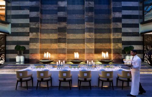 a man standing in front of a table with candles at Bengaluru Marriott Hotel Whitefield in Bengaluru