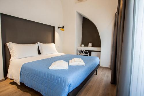 een slaapkamer met een blauw bed met 2 handdoeken erop bij Casa Nera GuestHouse in Montescaglioso