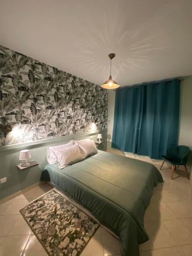 - une chambre avec un grand lit vert et une fresque murale dans l'établissement Appartement cosy à Rabat, à Rabat