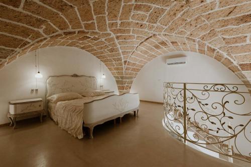 - une chambre avec un lit et un mur en briques dans l'établissement Borgo Felline Ospitalità Autentica, à Felline