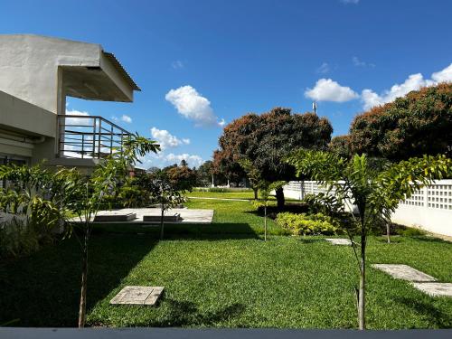 un cortile alberato, una recinzione e un edificio di Inhambane Hotel Escola a Inhambane