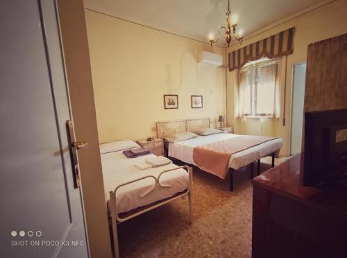 ヴィアレッジョにあるHotel Delhyのベッドルーム1室(ベッド2台、鏡付)