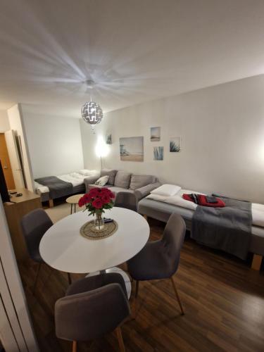 a living room with a couch and a table and a bed at Lovely studio apartment, glazed balcony and own parking space in Hyvinkää