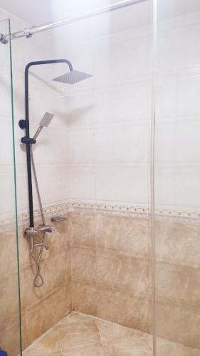 y baño con ducha y puerta de cristal. en Khách sạn Phong Lan Tam Đảo en Tam Ðảo