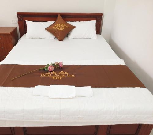 Una cama con cabecero de madera y flores. en Khách sạn Phong Lan Tam Đảo en Tam Ðảo