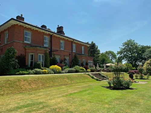 a large red brick house with a yard at The Upper House in Stoke on Trent