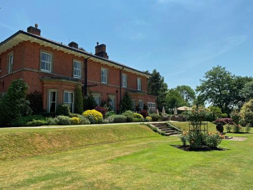 a large red brick house with a yard at The Upper House in Stoke on Trent