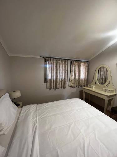 a bedroom with a white bed and a mirror at Eva beach hotel in Nydri