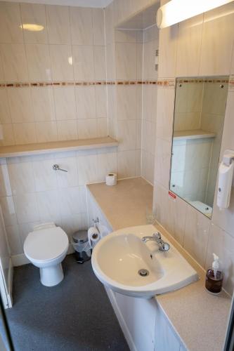 a white bathroom with a toilet and a sink at Edinburgh Whisky House Hotel in Edinburgh