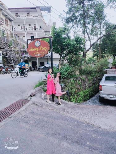 two young girls standing on the side of a street at Hoàng Long Hotel Tam Đảo in Tam Ðảo