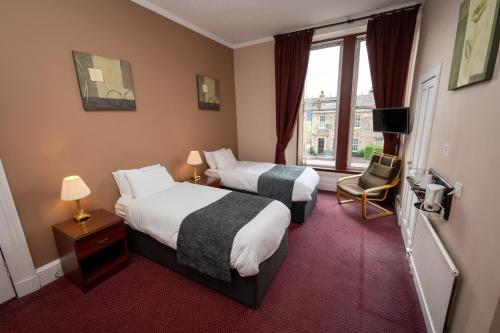 Habitación de hotel con 2 camas y ventana en Hampton Hotel by Greene King Inns, en Edimburgo
