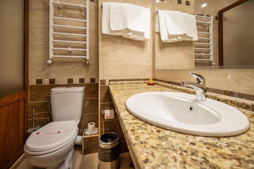 a bathroom with a white toilet and a sink at Sevastokrator Relax & Congress in Arbanasi