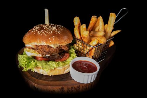 a hamburger and french fries and a basket of ketchup at LAKE VILLA by CARLSEN in Moratuwa