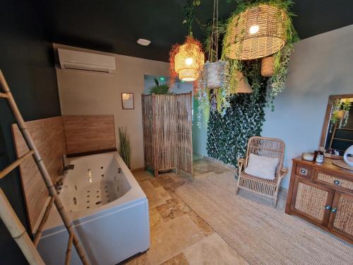 a bathroom with a tub and a chair in a room at La Love - Love room Marseille in Marseille