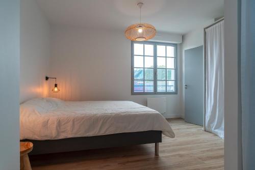 貝諾代的住宿－La Mouette - Appartement à 100m de la plage，一间卧室设有一张大床和一个窗户。