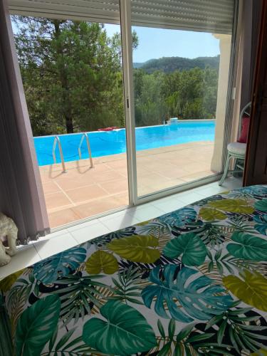 a bedroom with a bed and a view of a pool at VILLA MARILIS in Montauroux