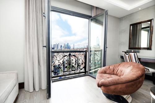 a living room with a chair and a large window at DoubleTree by Hilton Istanbul Gayrettepe in Istanbul