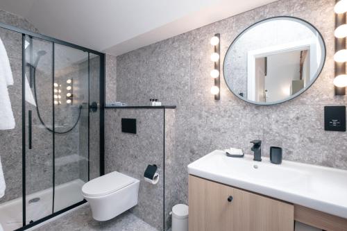 a bathroom with a toilet sink and a mirror at The Pillar Hotel in London