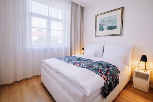 ein weißes Bett in einem Zimmer mit Fenster in der Unterkunft Rezidencia OPERA in Turčianske Teplice