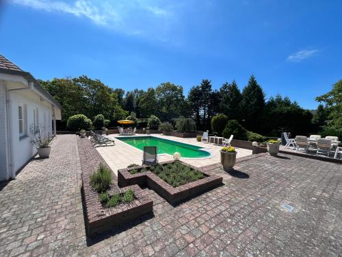 a backyard with a swimming pool and a brick patio at Villa Haagdoorn te Achel, 10 personen, 12 personen op aanvraag, met zwembad op het zuiden in een oase van rust! in Achel