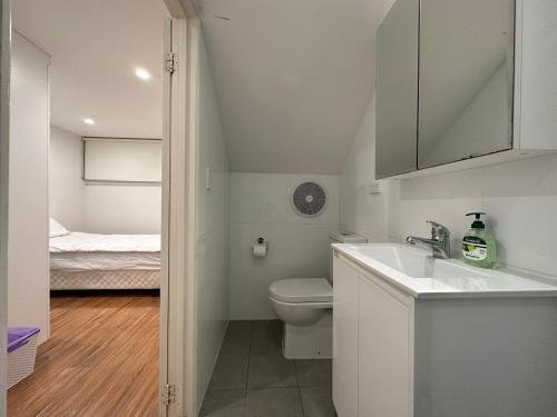 a bathroom with a sink and a toilet and a bed at Ultimo Terrace Homestay in Sydney