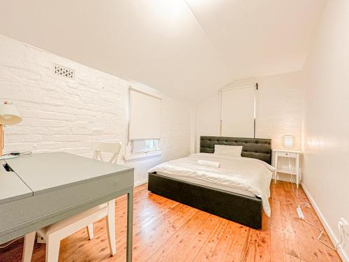 a bedroom with a bed and a desk in it at Ultimo Terrace Homestay in Sydney