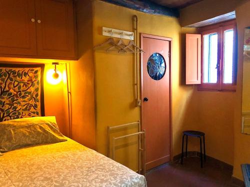 1 dormitorio con cama, puerta y ventana en Casa Odette Calcata, en Calcata