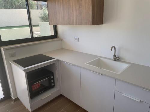 a white kitchen with a sink and a stove at dahan's 770 - דהן 770 in Safed