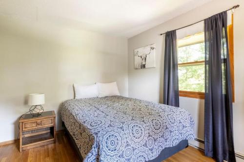 1 dormitorio con cama y ventana en Home on the hill, nestled in the woods., en Farmington