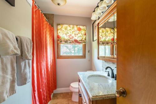 a bathroom with a sink and a toilet and a window at Home on the hill, nestled in the woods. in Farmington